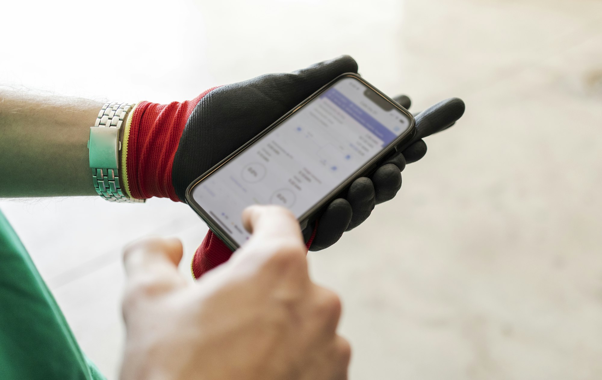 Main d'une personne tenant un téléphone portable utilisant une application d'énergie renouvelable. 