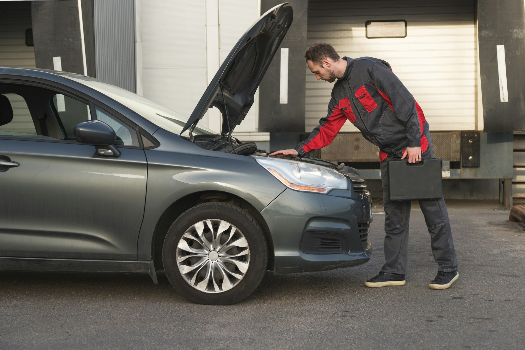 étui de rangement pour mécanicien automobile avec outils, regardez la voiture sous le capot pendant l'inspection technique du véhicule.