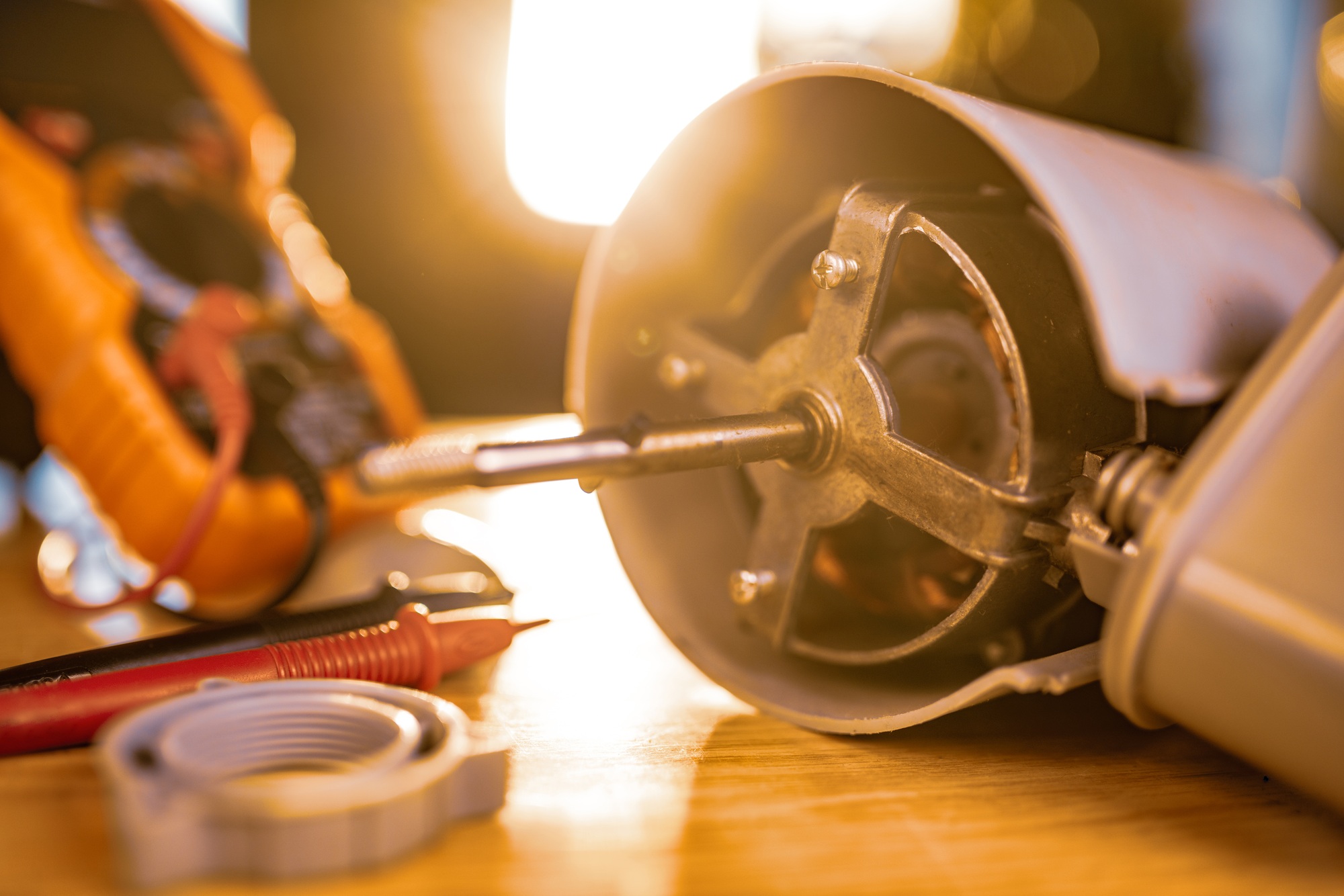 Le gros plan d'un moteur en fer à partir du ventilateur de refroidissement à domicile et des outils de test de test se trouve sur une table pendant la réparation dans un atelier spécialisé.