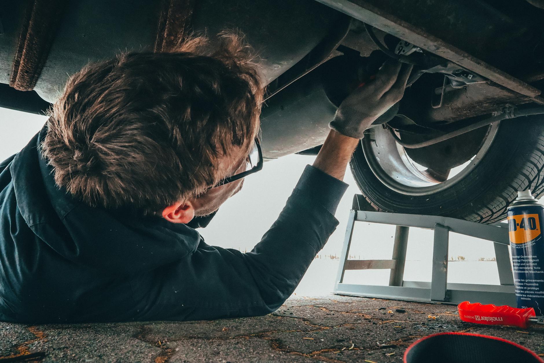 Mécanicien Réparation habilement du chariot automobile en extérieur avec outils.