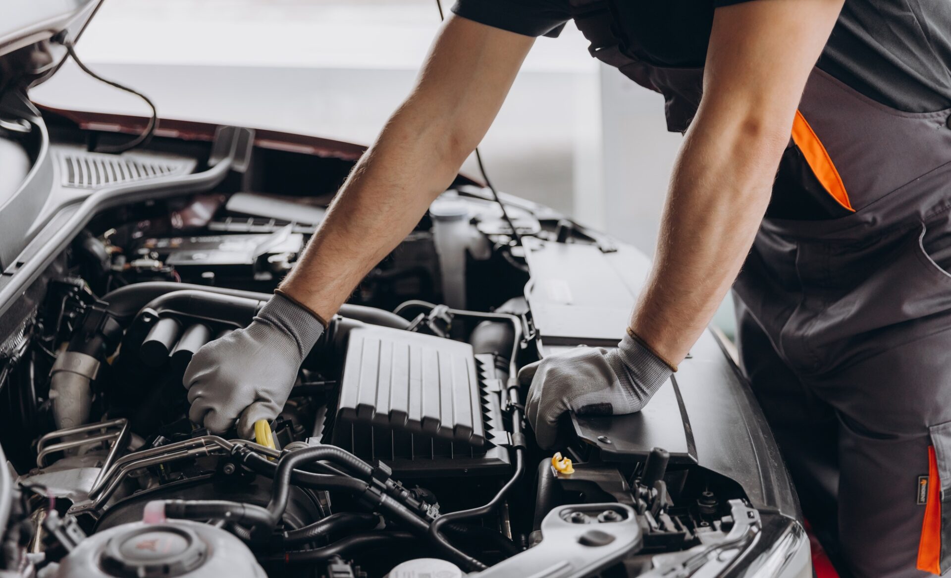 Close-up Fiche d'un homme méconnaissable portant un moteur de voiture d'inspection de gant gris et intérieur du capot de voiture